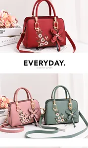 Detail of floral embroidery on colorful PU leather handbags with butterfly charm