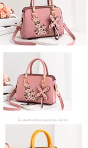 Detail of floral embroidery and butterfly charm on stylish pink and yellow handbags