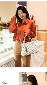 Détail d'un sac porté croisé blanc imprimé avec décoration à glands et métal doré