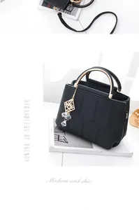 Detail of black PU leather handbag with hexagonal quilting and golden metal handle