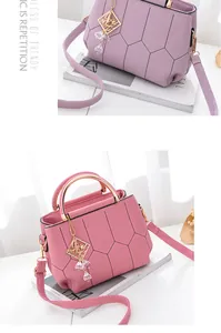 Close-up of quilted leather handbag with gold metal handles and decorative beaded charms