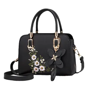Fashionable black faux leather handbag with floral embroidery and butterfly charm