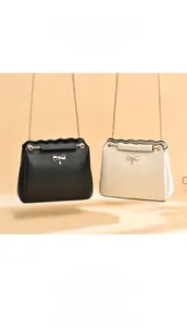 Detail of elegant flap bags with wavy edges, chain straps, and metal bow charms