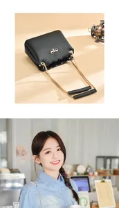 Detail of black crossbody bag featuring a golden bow clasp and stylish metal chain strap