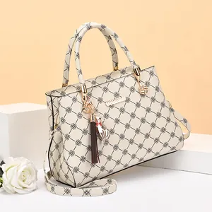 Sac à main crème pour femme avec motif trèfle, pompon décoratif et bandoulière réglable