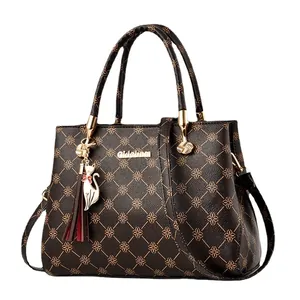 Sac à main marron imprimé avec motifs floraux, breloque pompon et bandoulière longue