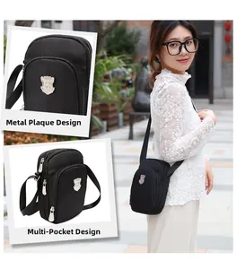 Dettaglio della borsa a tracolla in nylon nero con design multitasche e placca in metallo