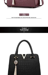 Detail of crocodile pattern texture on handbags with gold V-shaped hardware and long tassels