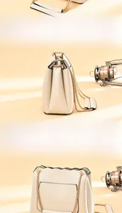 Detailed back view of cream crossbody bag featuring wavy pocket and gold chain strap