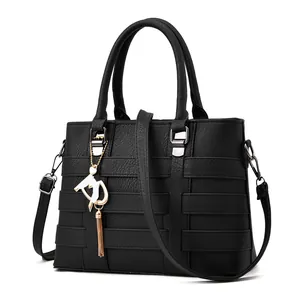 Large black woven leather handbag with double handles and decorative gold tassel pendant