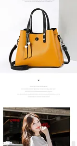 Detail of orange PU leather tote bag with heart charm and detachable shoulder strap