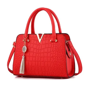 Elegant red crocodile pattern handbag with gold V-hardware and stylish tassel charm