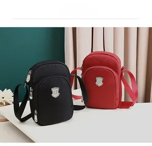 Dettaglio delle borse a tracolla in nylon rosso e nero con logo in metallo argento