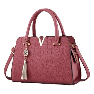 Classic burgundy crocodile embossed handbag with gold V-hardware and tassel pendant