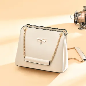 Cream chain crossbody bag with gold bow buckle and scalloped edges for women