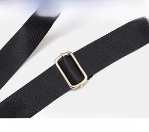 Dettaglio della tracolla regolabile in nylon nero con fibbia in metallo dorato
