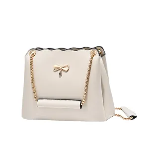 Trendy cream white crossbody bag with gold bow clasp and elegant chain strap design