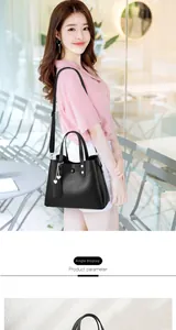 Detail view of stylish black PU leather bag with heart chain and adjustable strap