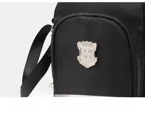 Dettaglio della borsa porta cellulare in nylon nero con targhetta in metallo argentato