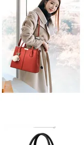 Détail du sac cabas rouge en cuir grainé avec pompon en peluche blanche et finitions dorées