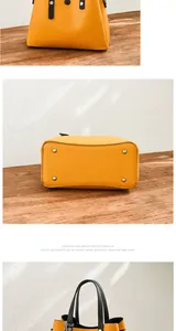 Detail of yellow leather handbag showing silver base studs and black contrast straps