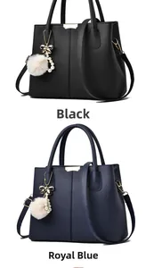 Détail de sacs en cuir grainé noir et bleu saphir avec pendentifs pompons en fourrure