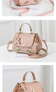 Detail of pink embroidered handbag with pearl H-lock and butterfly floral accents