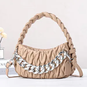 Detailed shot of the apricot ruched leather bag with a chunky silver chain and braided handle