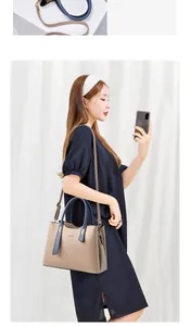 Close-up of stylish contrast color handbag with adjustable strap on female model