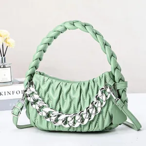 Detail view of mint green woven handle and pleated cloud bag with silver chain strap