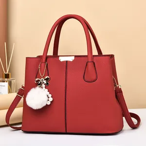 Sac à main rouge en cuir grainé avec pendentif en peluche et boucles dorées