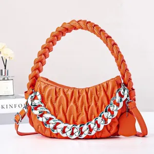 Orange quilted woven handbag with chunky silver chain and adjustable shoulder strap