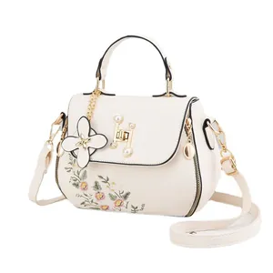 Chic beige crossbody bag featuring pink floral embroidery and pearl H-buckle hardware