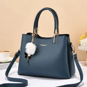Dark blue leather tote with lychee texture, golden hardware and white plush ball charm