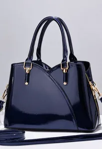 Dettaglio borsa a mano elegante in pelle verniciata blu navy con finiture in metallo dorato