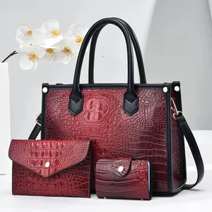 Three-piece red embossed crocodile pattern handbag set with tote, wallet and pouch