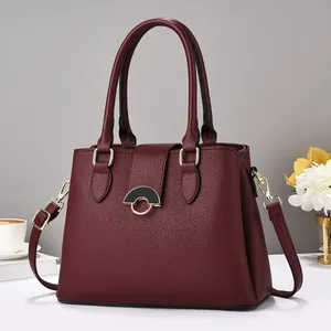Close-up of wine red lychee grain leather bag with elegant golden semicircular buckle