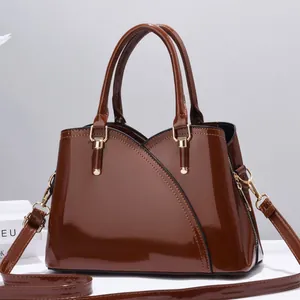 Elegante borsa a mano in pelle verniciata marrone scuro lucida con dettagli dorati