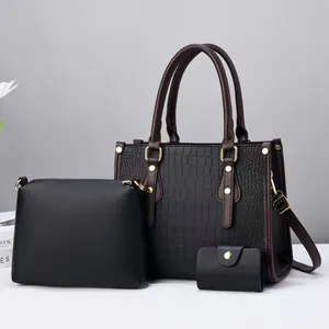 Three-piece black crocodile pattern handbag set with brown handles and gold hardware details
