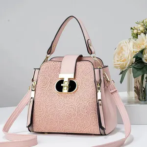 Détail du sac seau rose avec dentelle florale délicate et fermoir en métal doré en forme de T