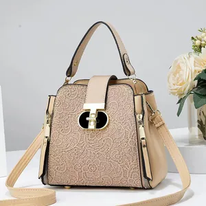Détail du sac seau beige avec dentelle florale délicate et fermoir pivotant en métal doré