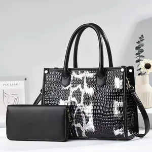 Close-up of black and white crocodile embossed tote bag and matching wallet set