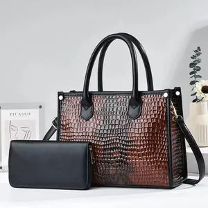 Detail shot of brown crocodile embossed tote bag and black matching long wallet set