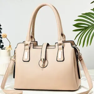 Dettaglio borsa beige in morbida pelle con finiture dorate e cerniere multistrato spaziose