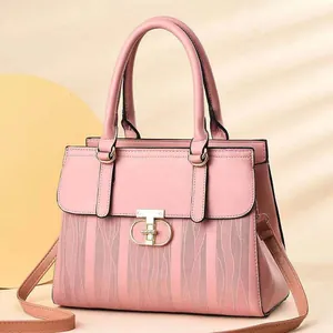 Pink striped leather handbag with golden hardware and adjustable strap shown on warm background