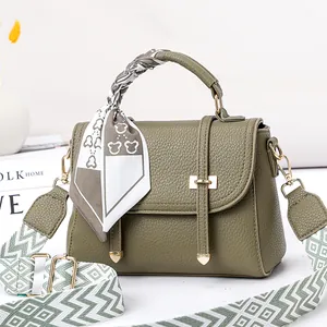 Détail du sac à main vert olive à motif litchi avec foulard en soie et sangle tissée