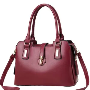 Borsa a mano in morbida pelle bordeaux con chiusura girevole dorata e tracolla
