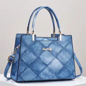 Blue denim texture quilted tote bag with gold metal logo and adjustable strap