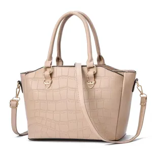 Dettaglio della borsa beige con trama a coccodrillo e finiture metalliche dorate