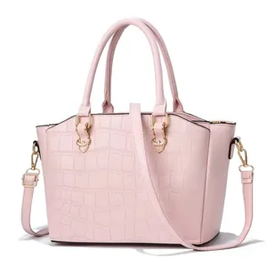 Dettaglio della trama a coccodrillo rosa e finiture dorate di questa borsa a mano
